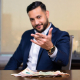 Mortgage broker showing commercial cap rate returns with cash on desk